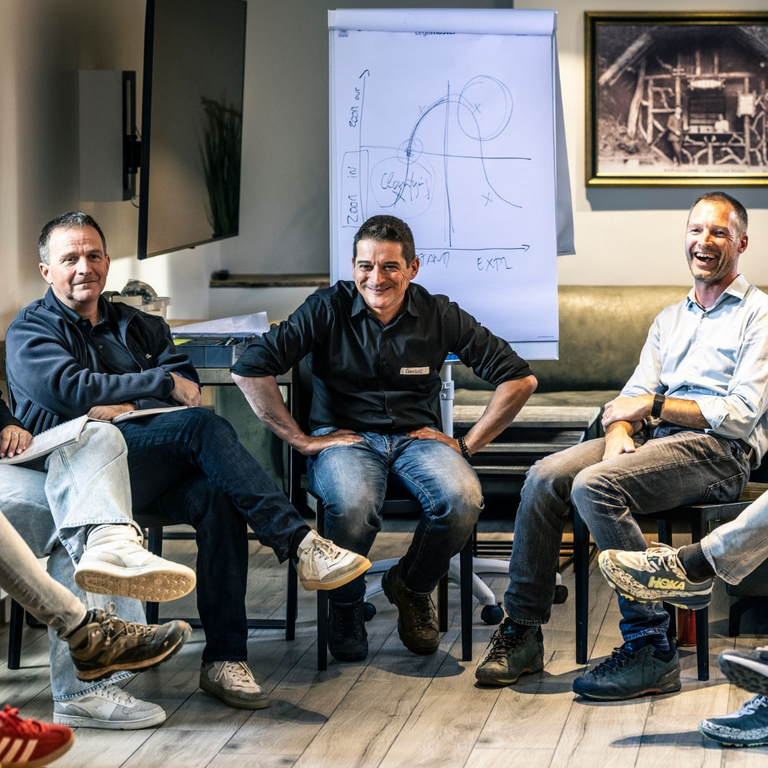 Lachende deelnemers in een kring tijdens een Beanmachine-sessie